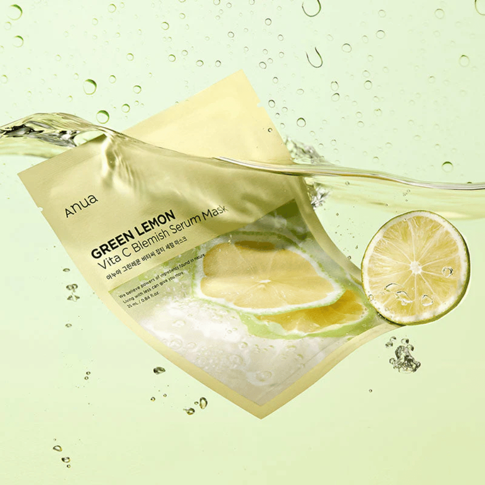 Żywy obraz opakowania Anua Green Lemon Vita C Blemish Serum Mask z przezroczystymi kroplami wody i plasterkami zielonej cytryny wokół. Opakowanie jest częściowo pokryte strumieniem wody na jasnym zielonym tle.