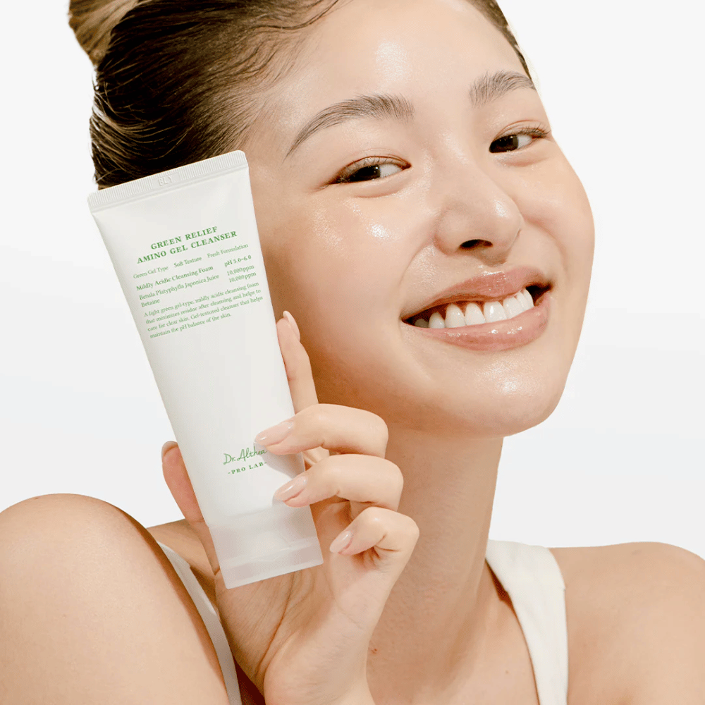Kobieta z promienną skórą trzyma Dr. Althea Green Relief Amino Gel Cleanser – wegański środek czyszczący dla wrażliwej i podrażnionej skóry.
