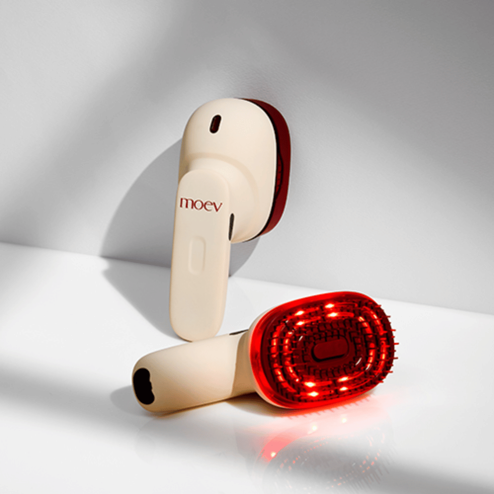 Dwa MOEV Hair Steamer Pro na białym tle. Jeden pokazuje aktywowane czerwone światła LED, które stymulują skórę głowy i poprawiają wzrost włosów.
