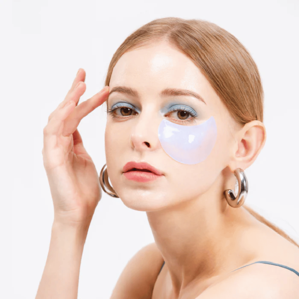 Model nosi niebiesko-lśniący hydrożelowy plaster pod okiem dla odświeżającego efektu.
