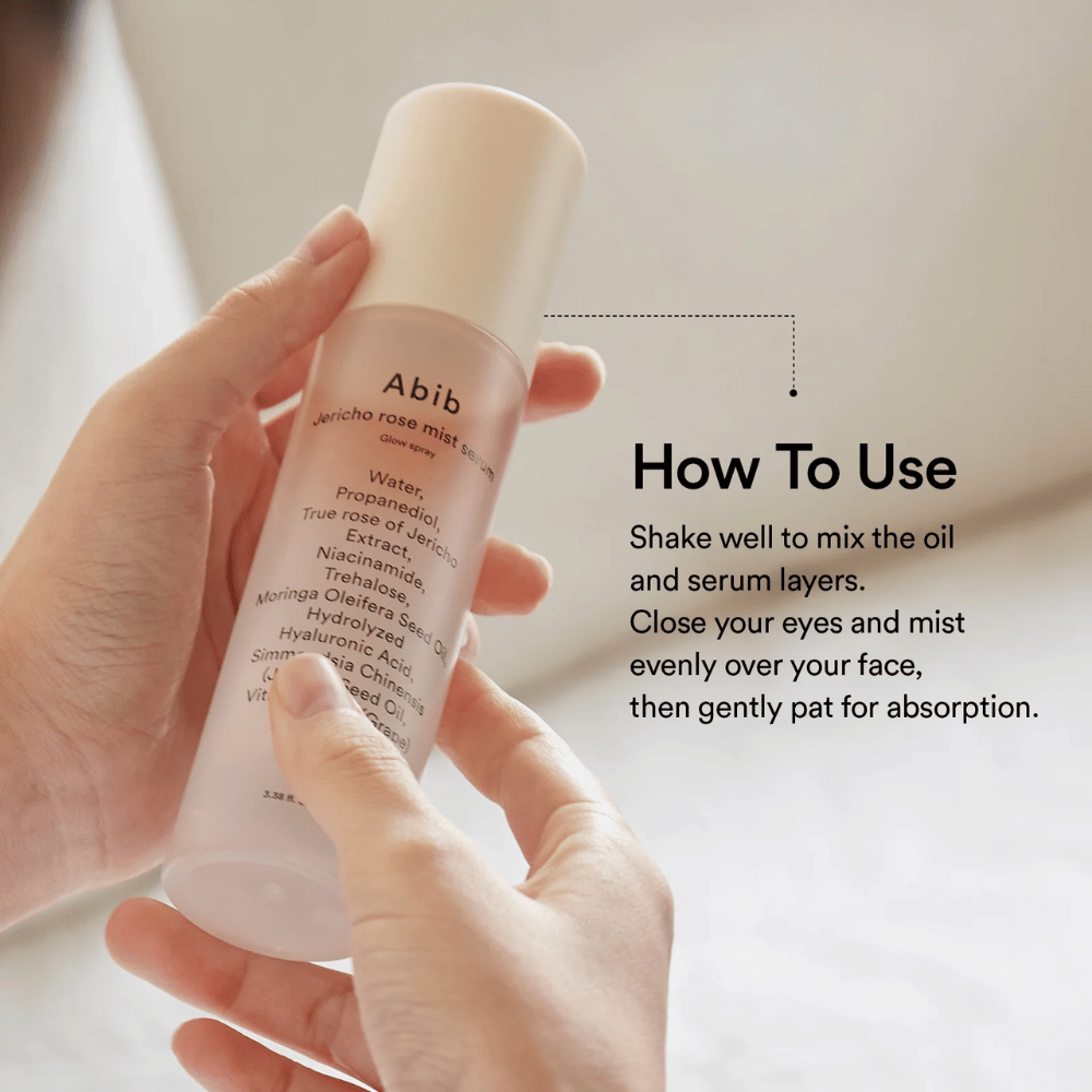Osoba trzyma Abib Jericho Rose Mist Serum i pokazuje, jak wstrząsać butelką, aby wymieszać olejek i serum przed użyciem.