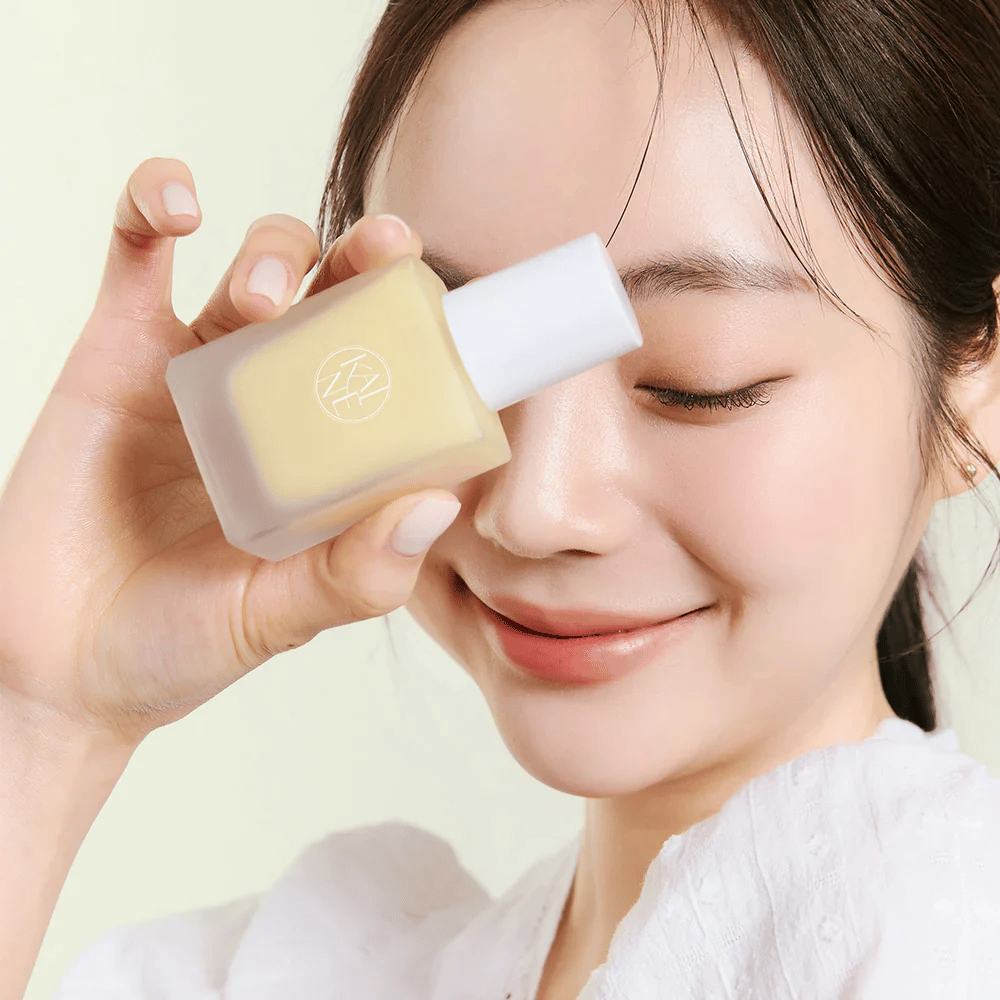 Kobieta trzyma butelkę KAINE Vita Drop Serum 30ml.