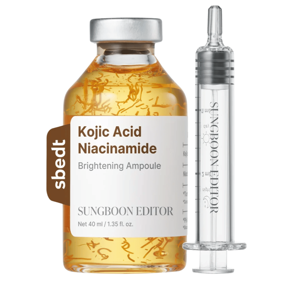 7. SUNGBOON EDITOR Kojic Acid Niacinamide Brightening Ampoule 40 ml – złota butelka serum z widocznymi aktywnymi nićmi i przezroczystym aplikatorem na białym tle