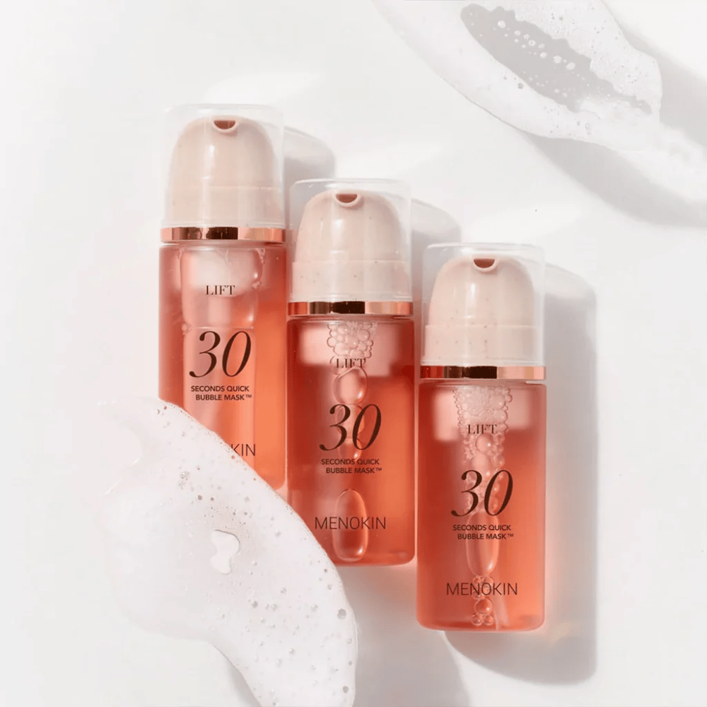 Estetyczne zdjęcie produktu z trzema butelkami MENOKIN LIFT 30 Seconds Quick Bubble Mask otoczonymi delikatną pianą, która podkreśla bąbelkowy i oczyszczający efekt.