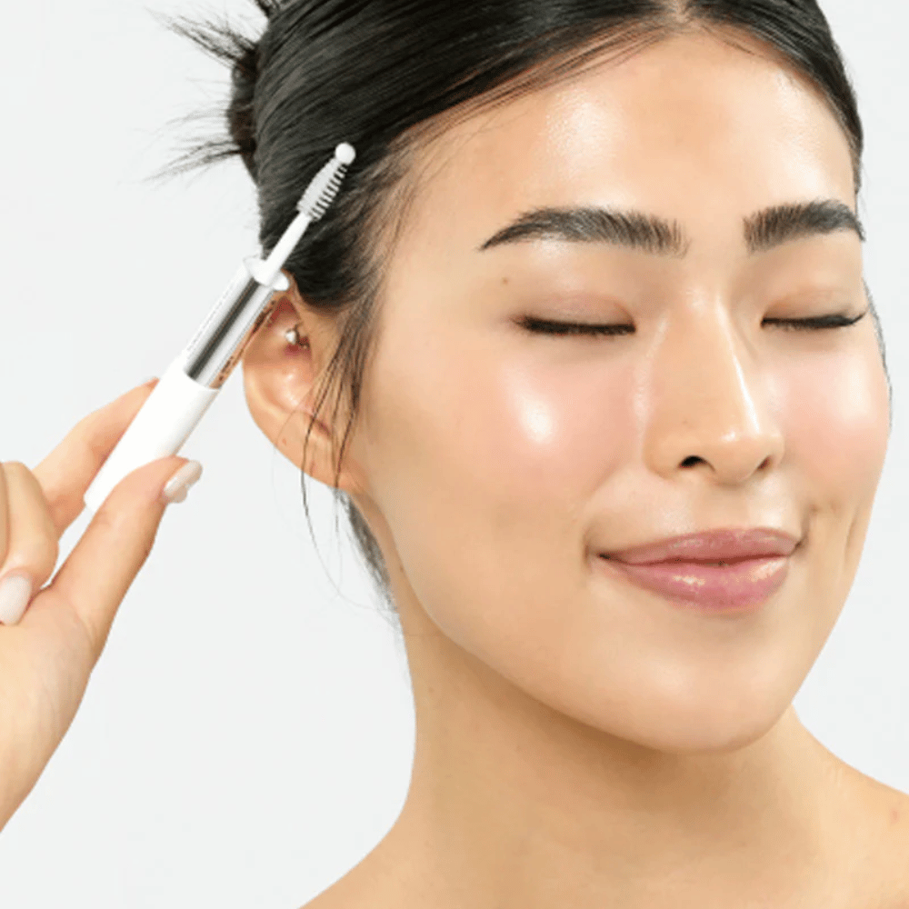 Kobieta aplikuje Seapuri Lashrum Eyelash Enhancing Serum na rzęsy. Wspomaga naturalny wzrost i blask.
