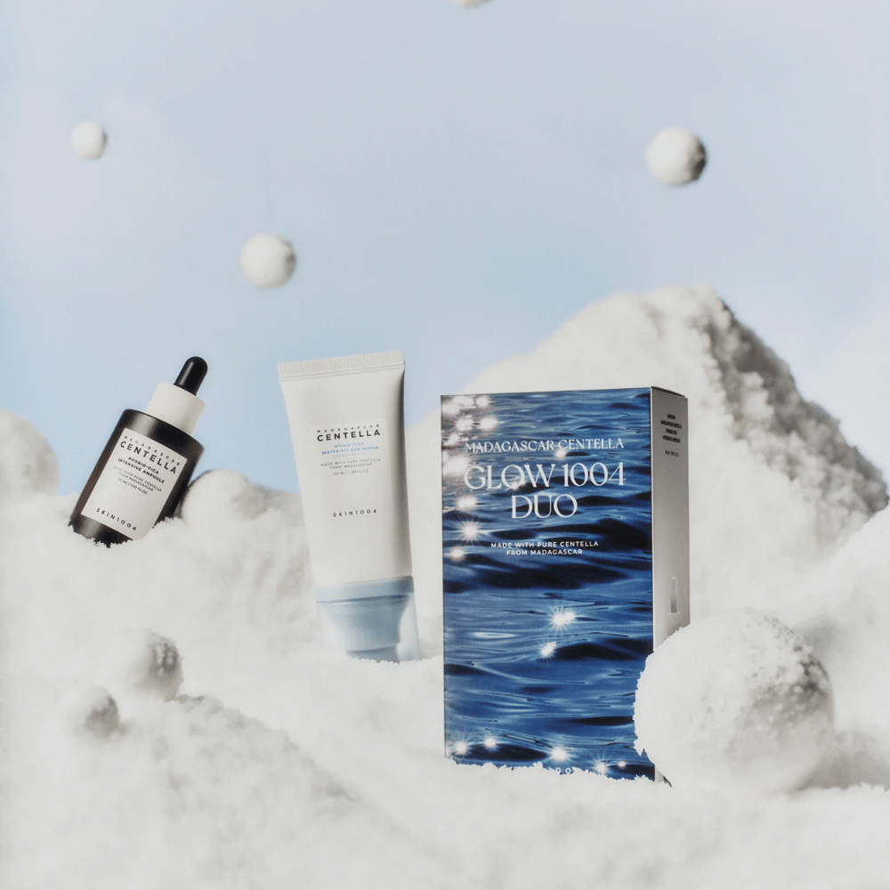 Obraz pokazuje zestaw do pielęgnacji skóry "Madagascar Centella Glow 1004 Duo" od SKIN1004, umieszczony na tle przedstawiającym śnieg i niebo.