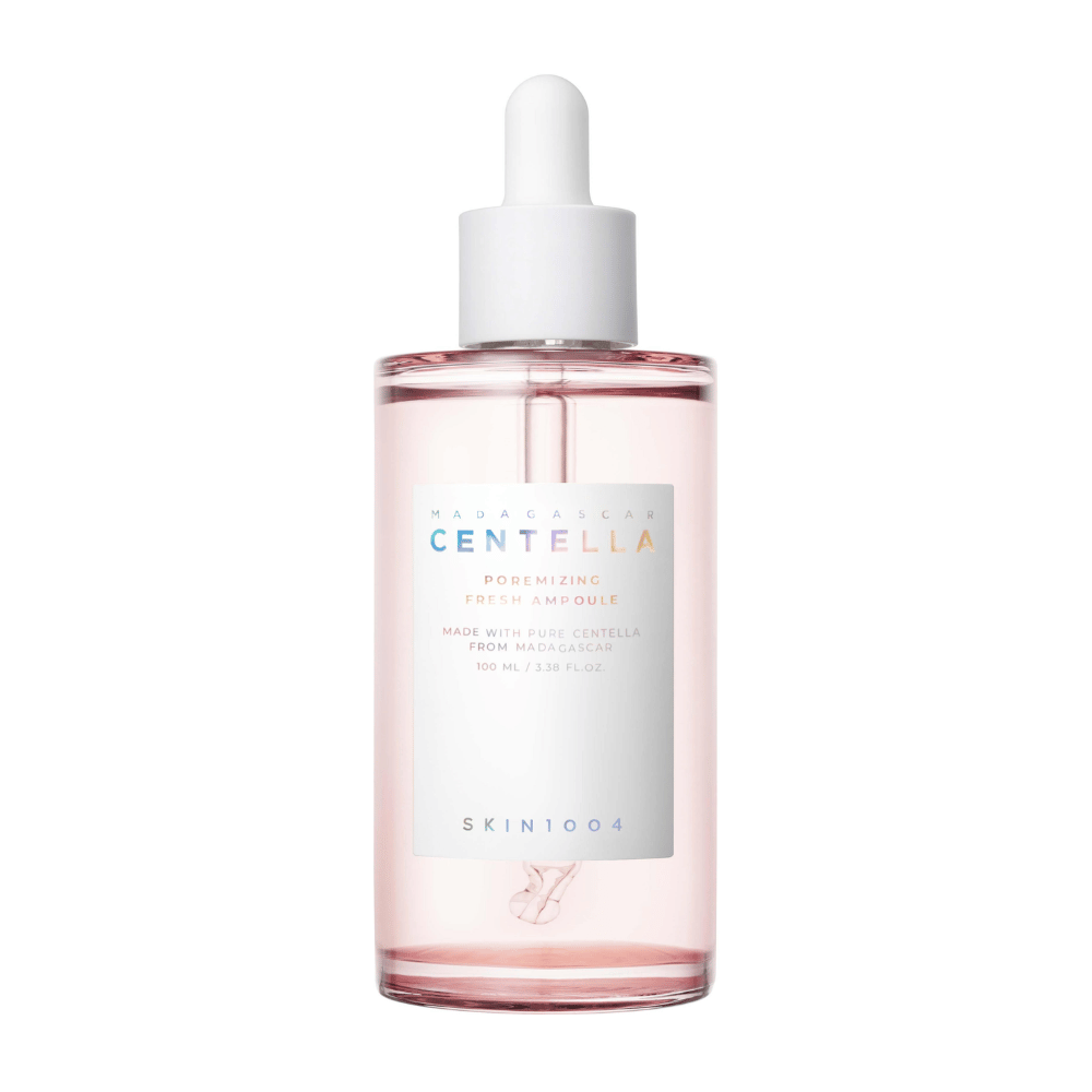 Przezroczysta butelka z różowym płynem i białą pipetą, SKIN1004 Madagascar Centella Poremizing Fresh Ampoule, na białym tle.