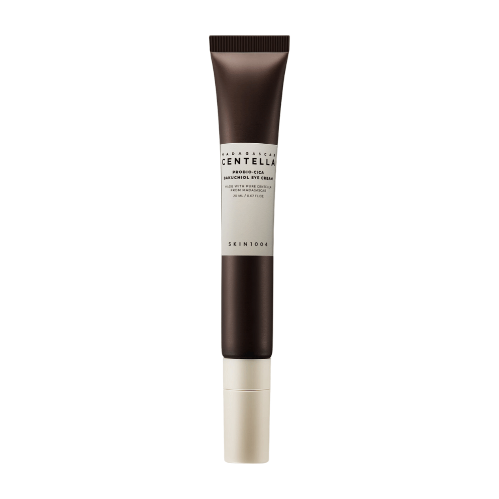 Tubka "Madagascar Centella Probio-Cica Bakuchiol Eye Cream" z SKIN1004. Produkt jest zaprojektowany do okolic oczu i zawiera składniki takie jak centella z Madagaskaru i bakuchiol, znane ze swoich właściwości pielęgnacyjnych i nawilżających. Tubka jest elegancka z ciemnobrązowym kolorem przechodzącym w biały.