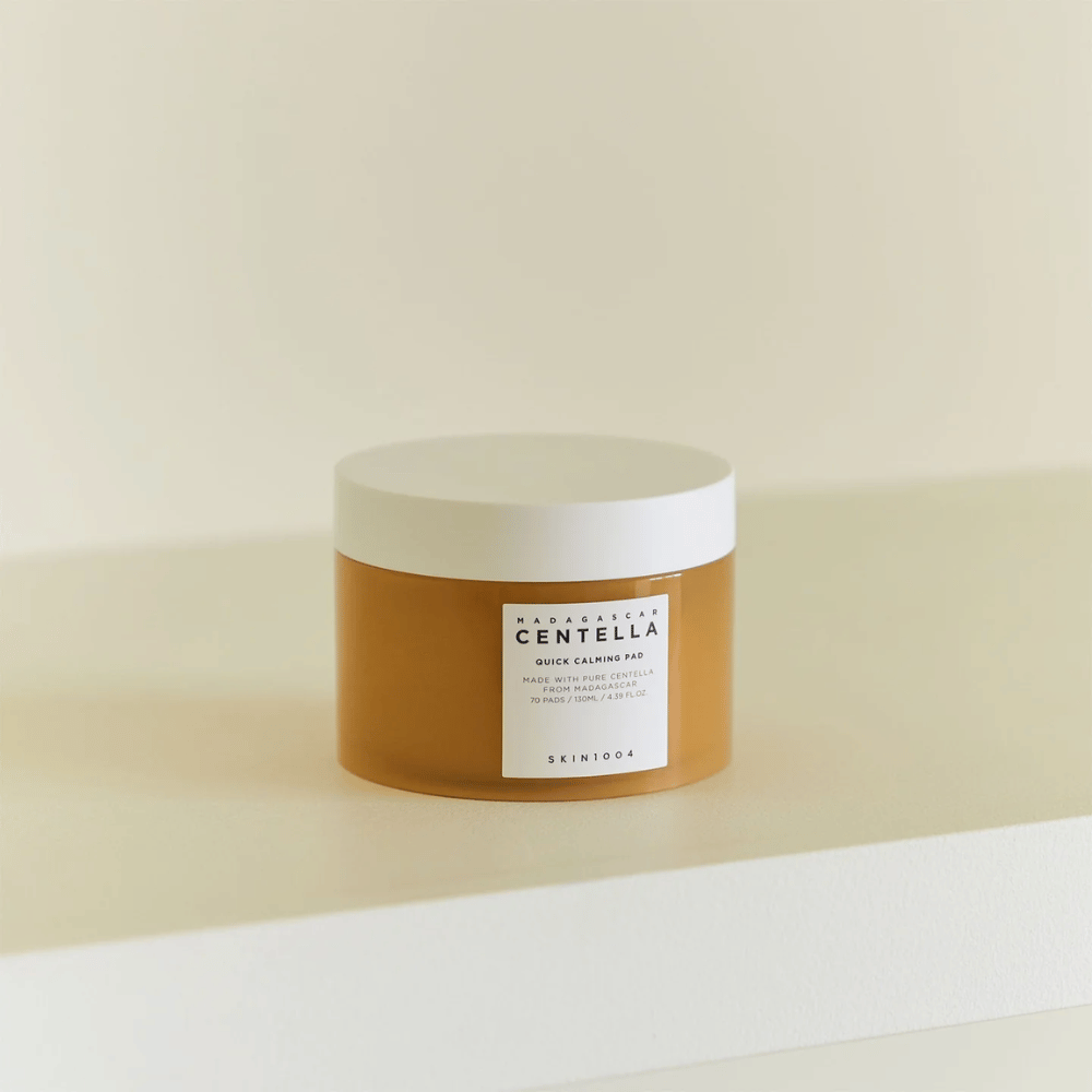 SKIN1004 Madagascar Centella Quick Calming Pad umieszczony na białej półce – bursztynowy słoik z białą pokrywką i wyraźną etykietą z przodu.