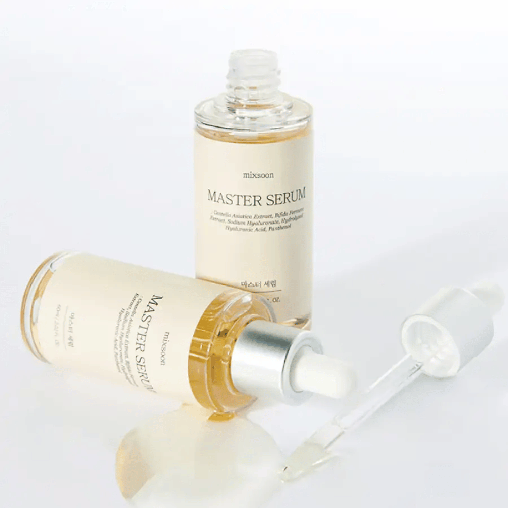 Dwie butelki Mixsoon Master Serum, jedna stojąca i jedna leżąca z otwartą pipetą, gdzie serum wylało się na białą powierzchnię.
