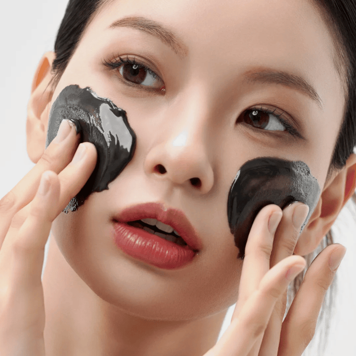 Zbliżenie aplikacji Jak Midnight Soothing Cleansing Balm na twarz. Miękki balsam oczyszczający, który rozpuszcza zanieczyszczenia i daje uczucie spokoju skórze.