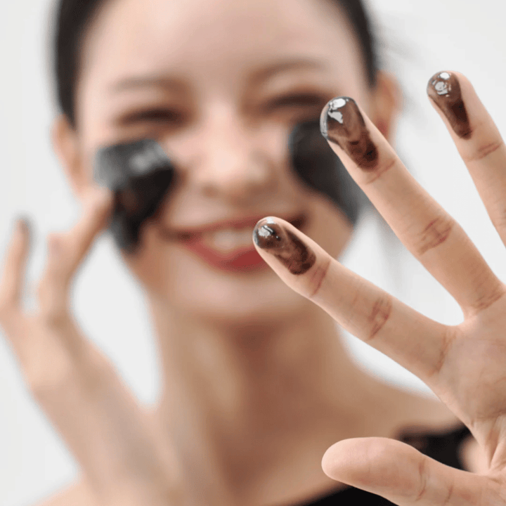 Modelka aplikuje Jak Midnight Soothing Cleansing Balm na skórę. Kremowy balsam oczyszczający, który dogłębnie oczyszcza i pozostawia skórę miękką i zrównoważoną.