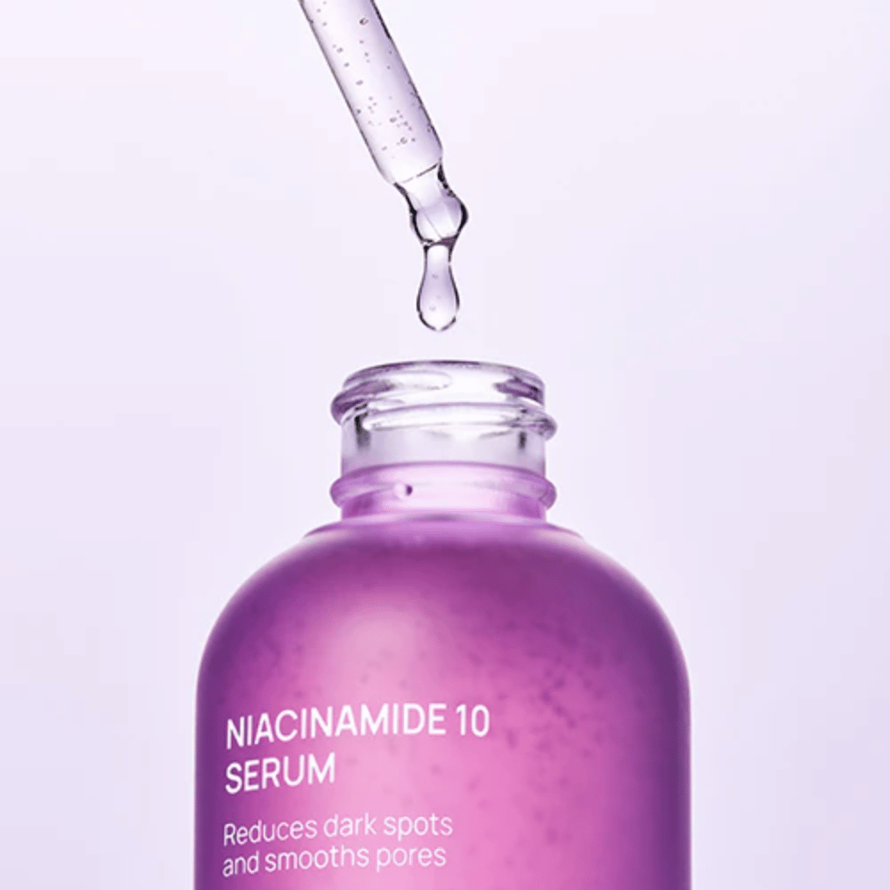 Zbliżenie na butelkę i pipetę z Jumiso Niacinamide 10 Serum. Przezroczysta kropla lekkiej formuły, która szybko wchłania się w skórę.