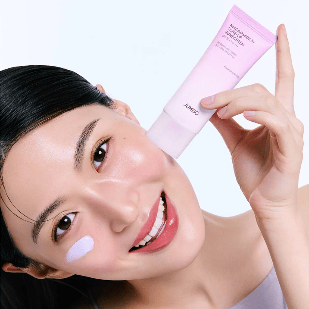 Modelka nakłada JUMISO Niacinamide 3+ Tone-Up Sunscreen SPF50+ PA++++ dla ochrony UV, bardziej wyrównanego kolorytu skóry i naturalnego blasku.