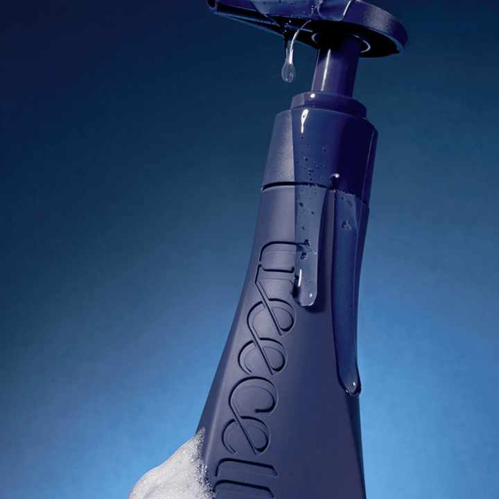 Ciemne i ekskluzywne zdjęcie produktu Treecell Night Collagen Shampoo z kroplami wody i pianą, które podkreślają właściwości nawilżające i oczyszczające.