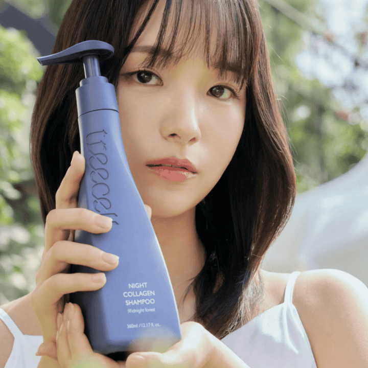 Kobieta trzyma Treecell Night Collagen Shampoo Midnight Forest w naturalnym otoczeniu. Obraz przekazuje zdrowe włosy, blask i premium charakter, z naciskiem na pielęgnację włosów i skóry głowy.