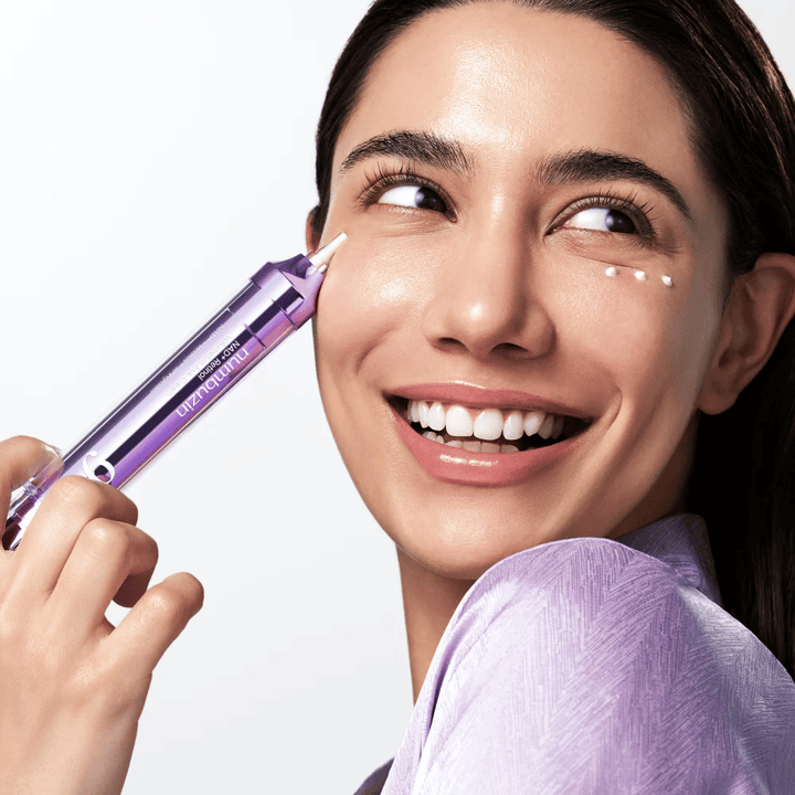 Modelka nakładająca No.9 NAD+ Retinol Volumetox Eye Cream wokół oczu z aplikatorem precyzyjnym, dla ukierunkowanej pielęgnacji przeciw cieniom i drobnym liniom.