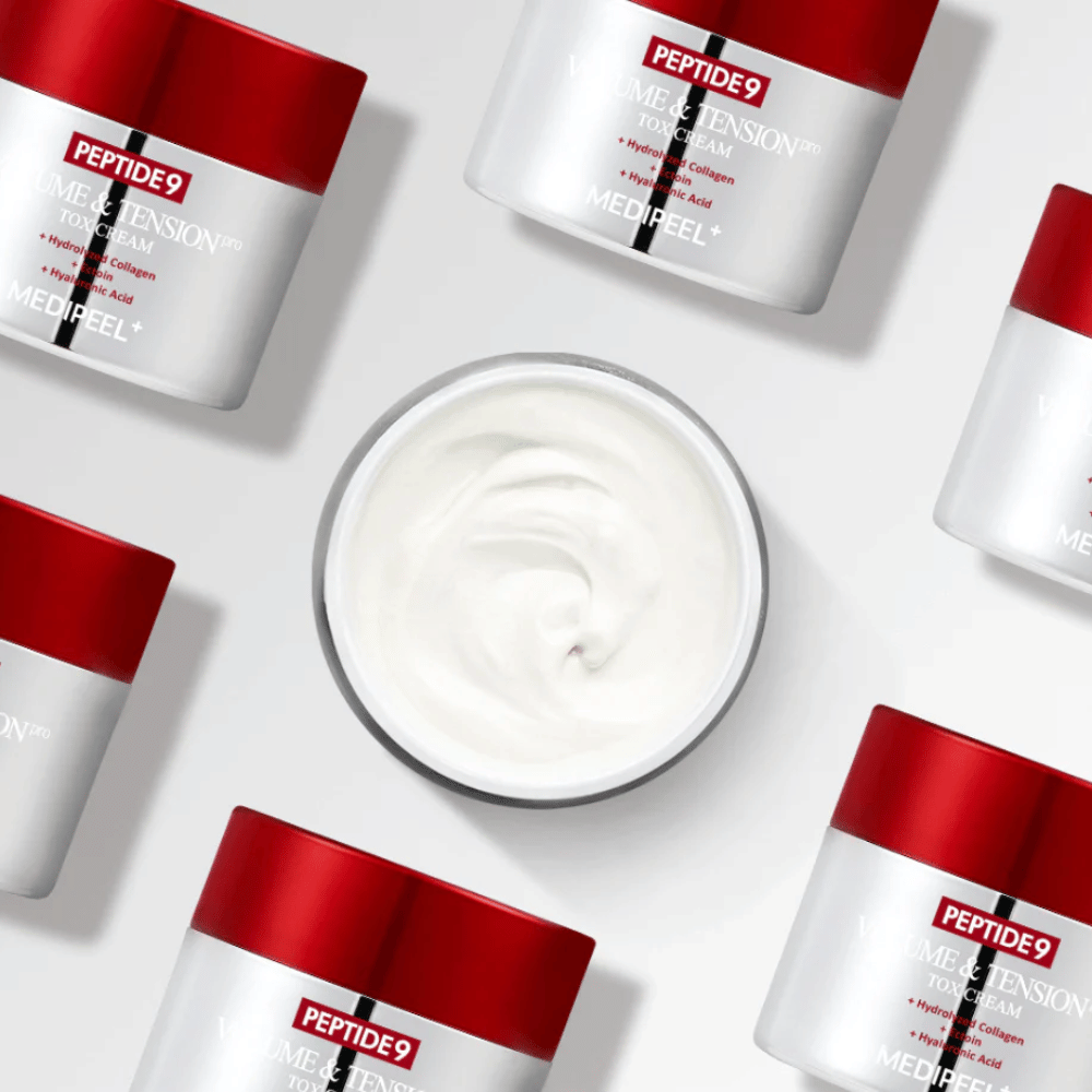 Kilka słoików MEDI-PEEL Peptide 9 Volume & Tension Tox Cream ułożonych na białym tle. Produkt intensywnie nawilża i nadaje skórze objętość i blask.