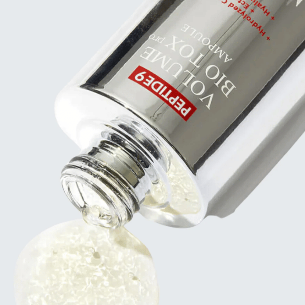 Zbliżenie na MEDI-PEEL Peptide 9 Volume Bio Tox Pro Ampoule podczas wylewania. Przezroczysta formuła z kolagenem, ectoiną i kwasem hialuronowym głęboko nawilża.