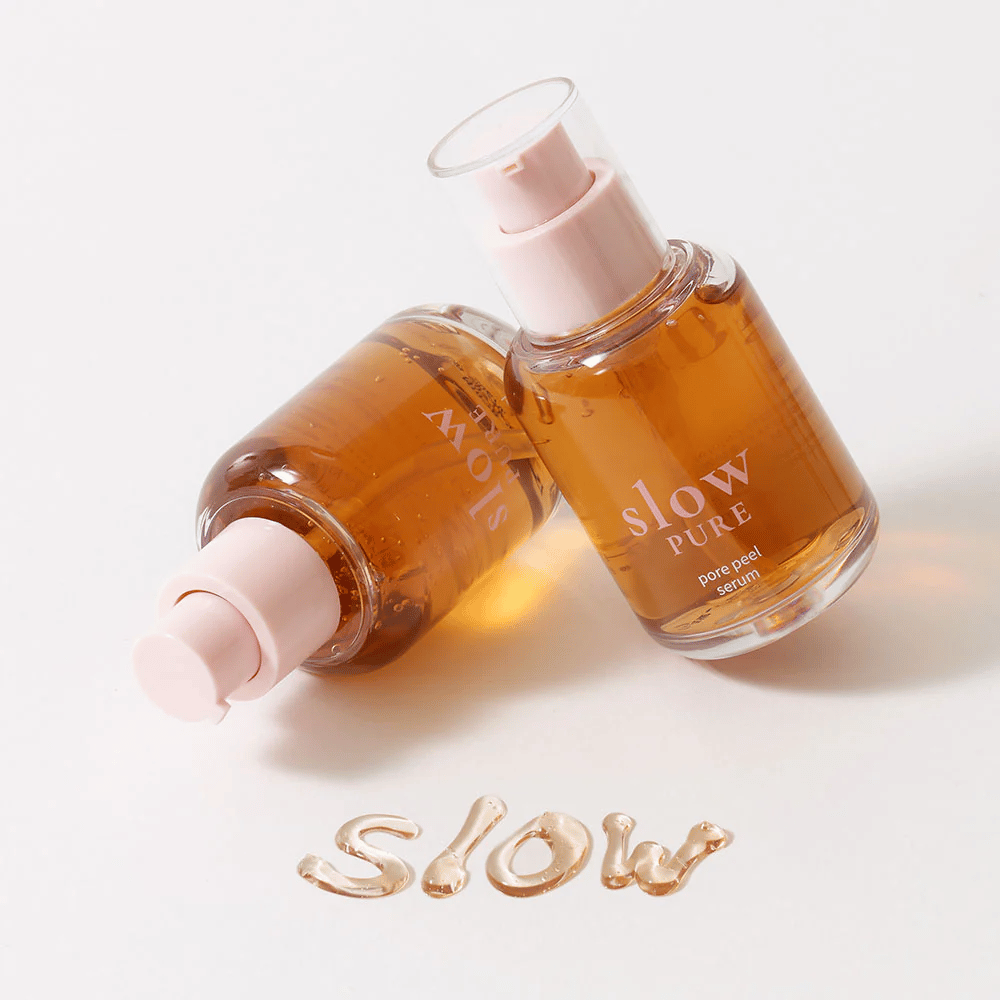 Dwie butelki Slow Pure Pore Peel Serum z pompką, tekst napisany serum na powierzchni: "Slow".