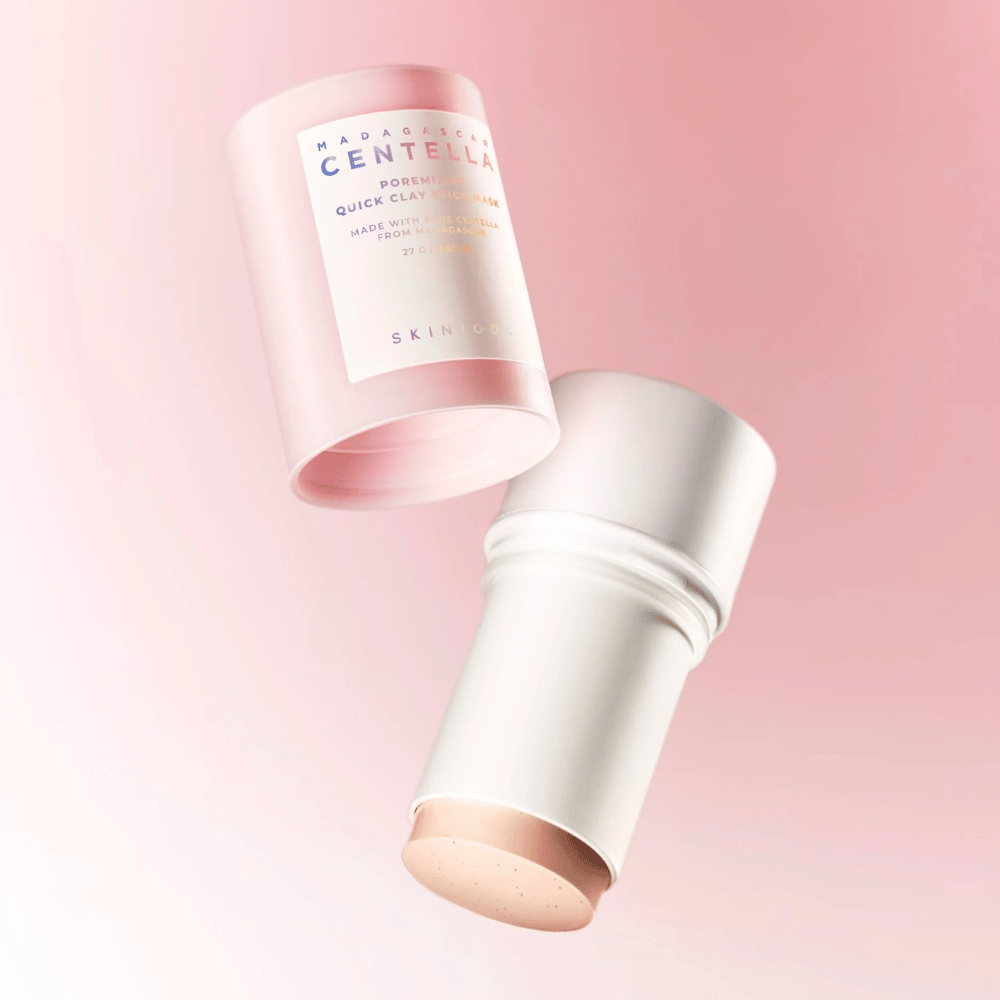 SKIN1004 Madagascar Centella Poremizing Quick Clay Stick Mask w eleganckim różowym i białym designie. Praktyczna forma sztyftu dla łatwej aplikacji i głębokiego oczyszczania.