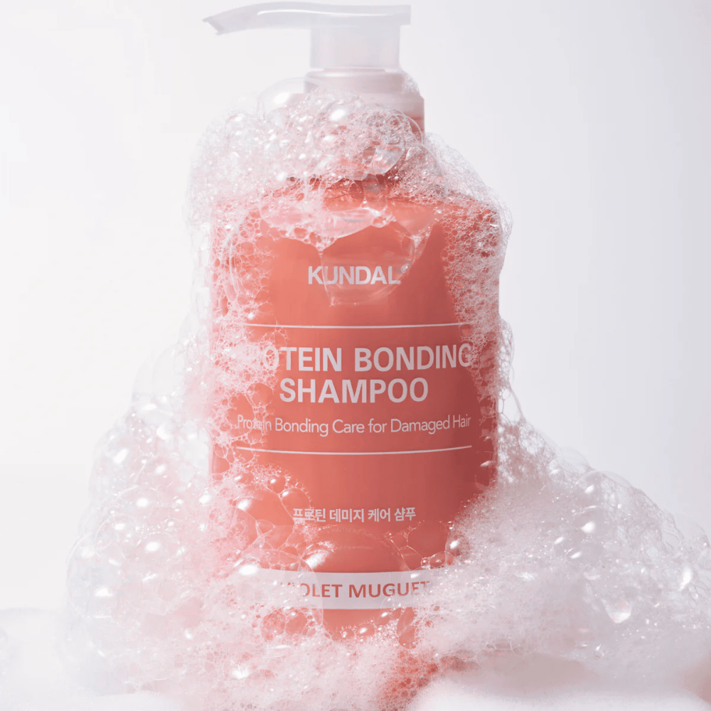 KUNDAL Protein Bonding Shampoo Violet Muguet pokryte obfitą pianą, szampon regenerujący do zniszczonych włosów.