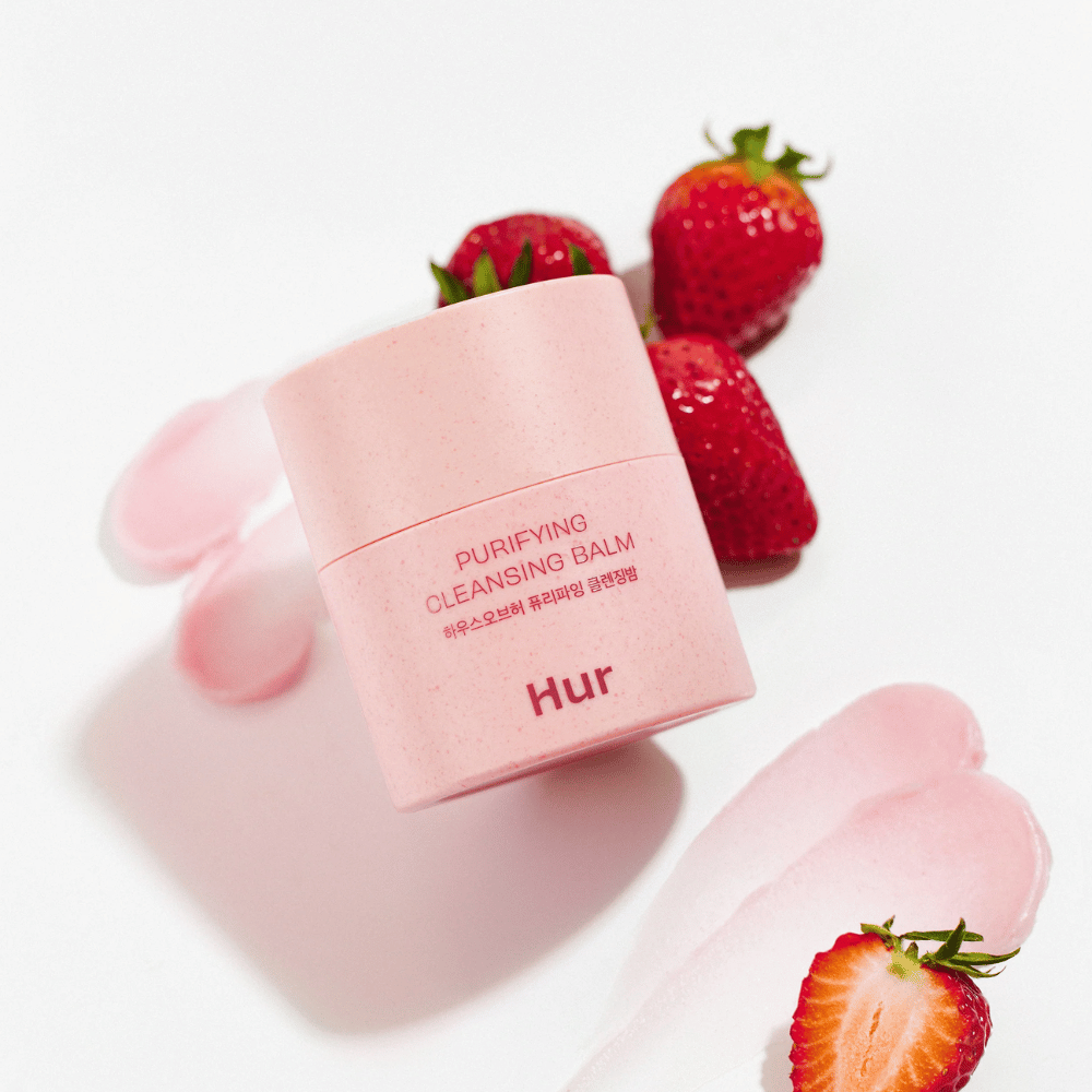Jak Purifying Cleansing Balm umieszczony z świeżymi truskawkami. Oczyszczający balsam, który nadaje gładką skórę i nadaje się do codziennego oczyszczania twarzy.