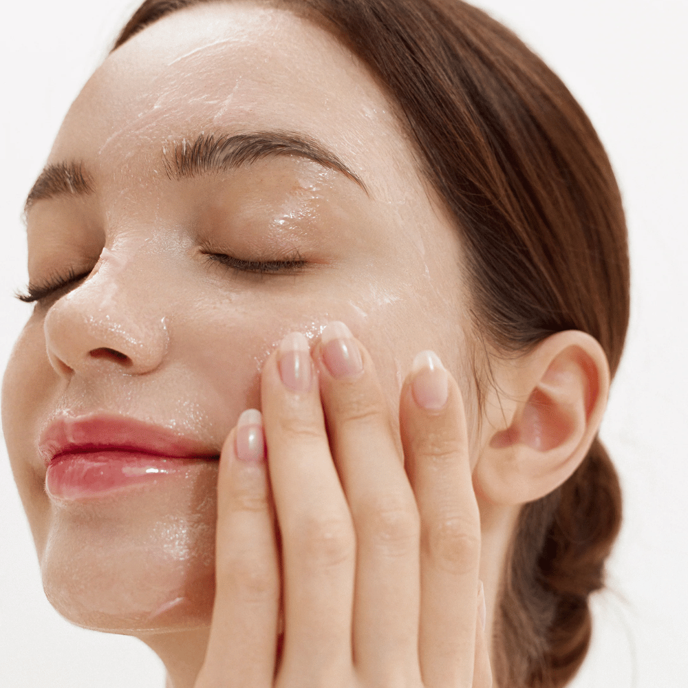 Jak Purifying Cleansing Balm jest aplikowany na twarz. Kremowy balsam, który topi się w kontakcie ze skórą i delikatnie usuwa brud, filtry przeciwsłoneczne i makijaż.
