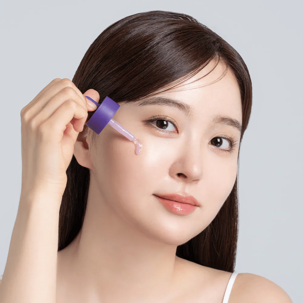 Aplikacja Cellology Purple Carrot Pore Ampoule pipetą na twarz do pielęgnacji porów i wyrównania tekstury skóry.