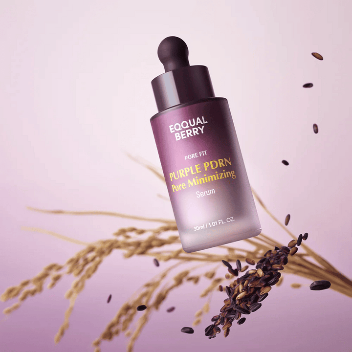 Flaska med Equal Berry Purple PDRN Pore Minimizing Serum svävar mot lila bakgrund, omgiven av svarta risgryn och risstrån.