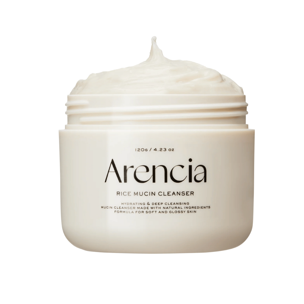 Zdjęcie produktu Arencia Rice Mucin Cleanser w białym słoiku z kremową, ubijaną teksturą wystającą z otworu. Tekst na opakowaniu podkreśla nawilżenie i głębokie oczyszczanie.