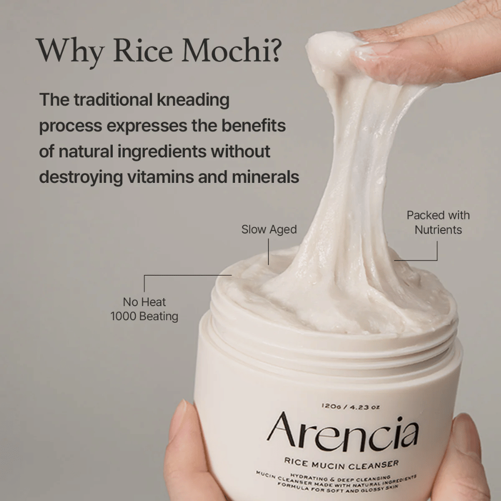 Ręka podnosząca elastyczny, biały krem oczyszczający ze słoika oznaczonego "Arencia Rice Mucin Cleanser". Tekst opisuje tradycyjne ugniatanie, które zachowuje składniki odżywcze bez niszczenia witamin i minerałów.