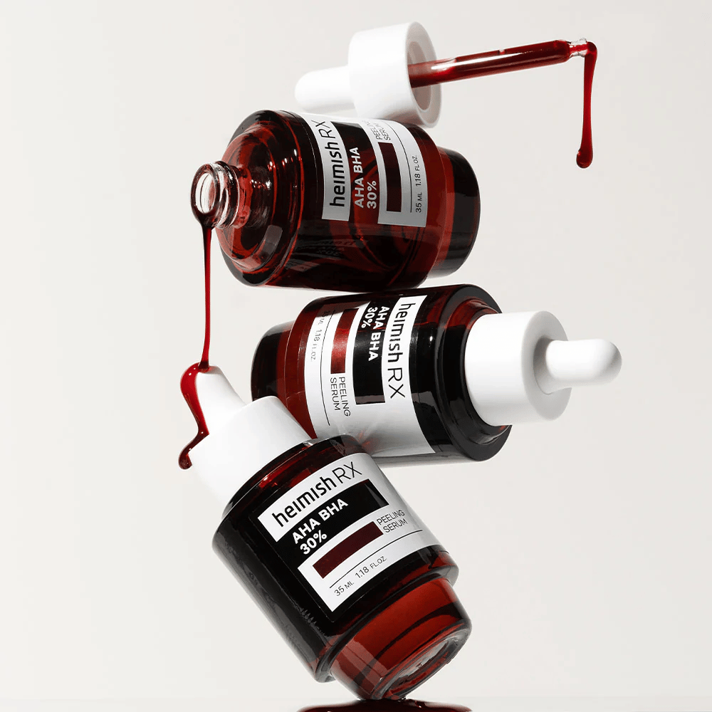 Trzy butelki Heimish RX AHA BHA 30% Peeling Serum w dynamicznej kompozycji, z czerwonym serum kapiącym z pipet.