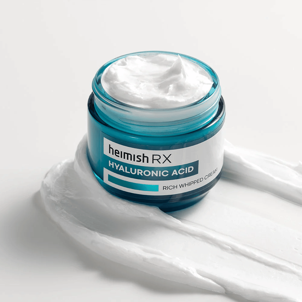 Heimish RX Hyaluronic Acid Rich Whipped Cream w niebieskim szklanym słoiku o bogatej i puszystej konsystencji, rozłożony na białym tle. Intensywnie nawilżający krem do twarzy z kwasem hialuronowym dla głębokiego nawilżenia i miękkiej skóry.