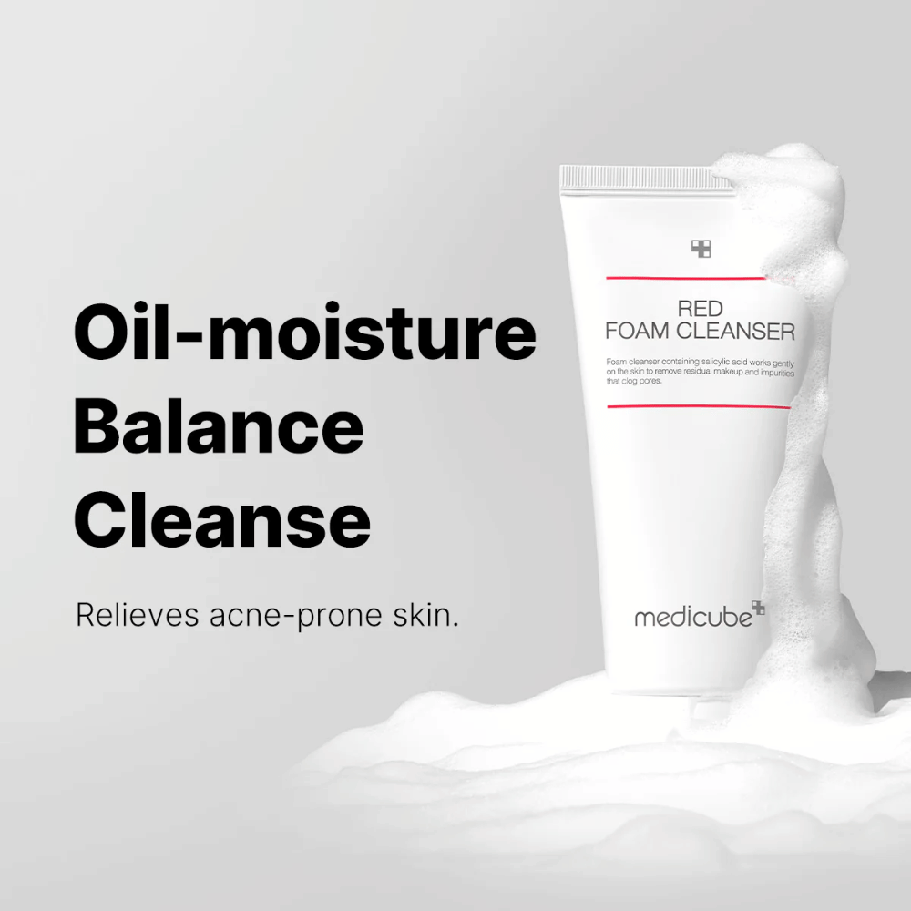 Tuba z Medicube Red Foam Cleanser stoi pionowo wśród pieniącej się piany. Tekst „Oil-moisture Balance Cleanse” jest wyświetlany po lewej stronie, z opisem „Relieves acne-prone skin” poniżej. Tło jest jasnoszare.