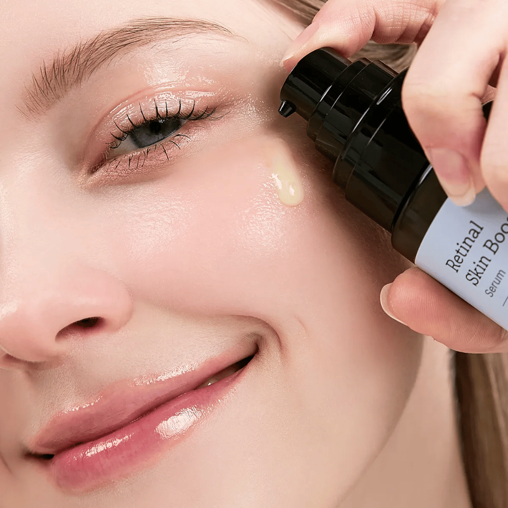 Osoba aplikuje Meditherapy Retinal Skin Booster Serum blisko oka. Serum ma lekką, żółtą tonację i nadaje skórze blasku oraz jędrności.
