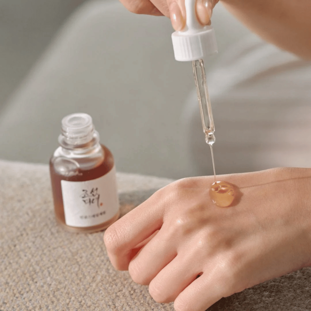 Pipeta nakłada Beauty of Joseon Revive Serum Ginseng + Snail Mucin na skórę – koreańskie serum dla elastyczności i nawilżenia.
