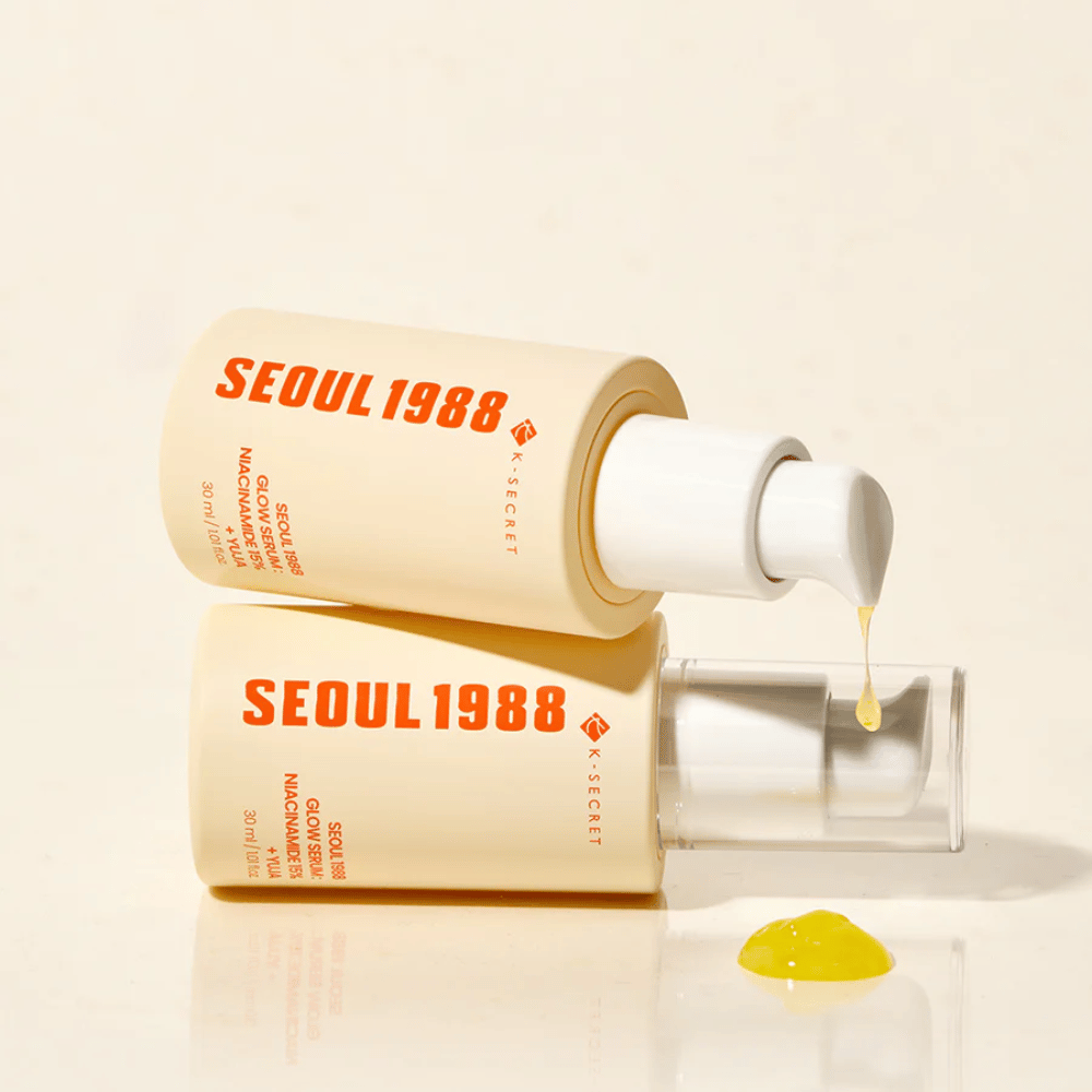 Dwie butelki Seoul 1988 Glow Serum leżące i stojące, z żółtym serum kapiącym z pompki.