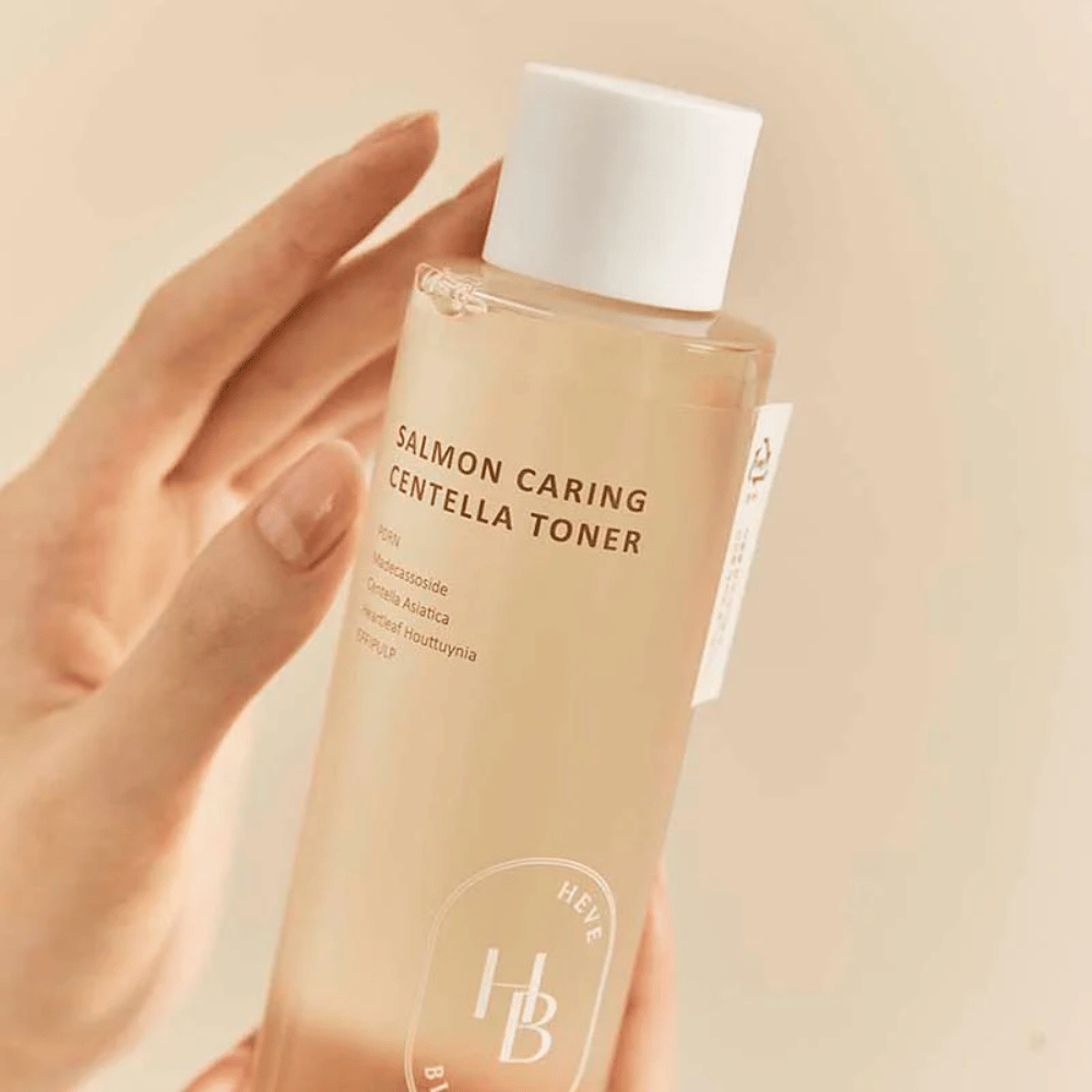 Zbliżenie na Salmon Caring Centella Toner w dłoni – tonik łagodzący z PDRN i ekstraktami roślinnymi, które pomagają wzmocnić skórę i zmniejszyć uczucie podrażnienia.