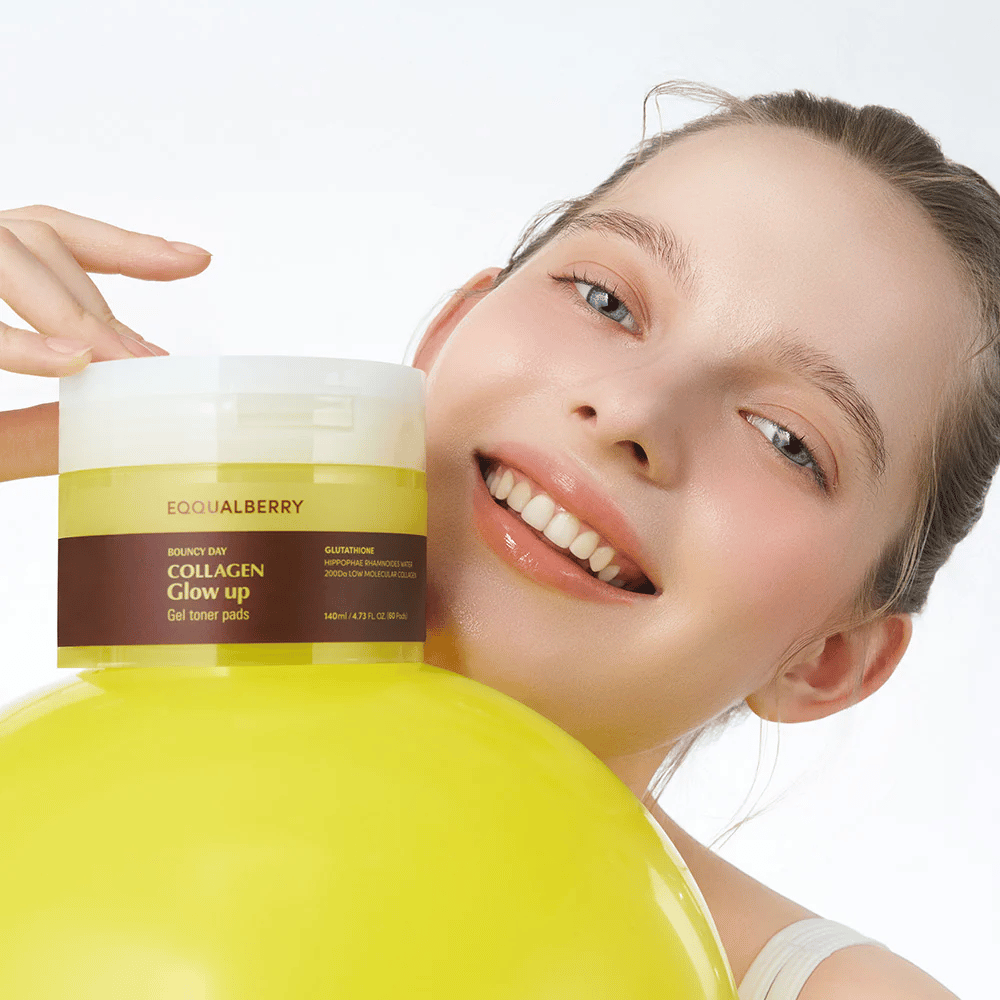 Uśmiechnięta modelka trzymająca Bouncy Day Collagen Glow up Gel Toner Pads, który pomaga nadać młodzieńczy blask i jędrność dzięki niskocząsteczkowemu kolagenowi i glutationowi.