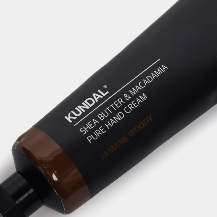 Zbliżenie na KUNDAL Shea Butter & Macadamia Pure Hand Cream Jasmine Woody pokazujące stylowe opakowanie i premium wrażenie kremu do rąk.