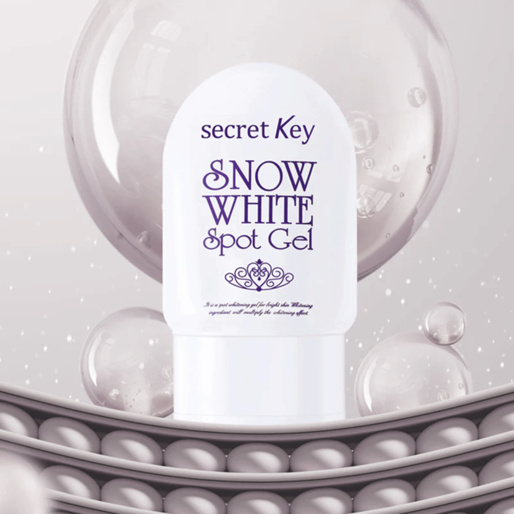 Secret Key Snow White Spot Gel w białym opakowaniu na tle z bąbelkami i perłowymi detalami.