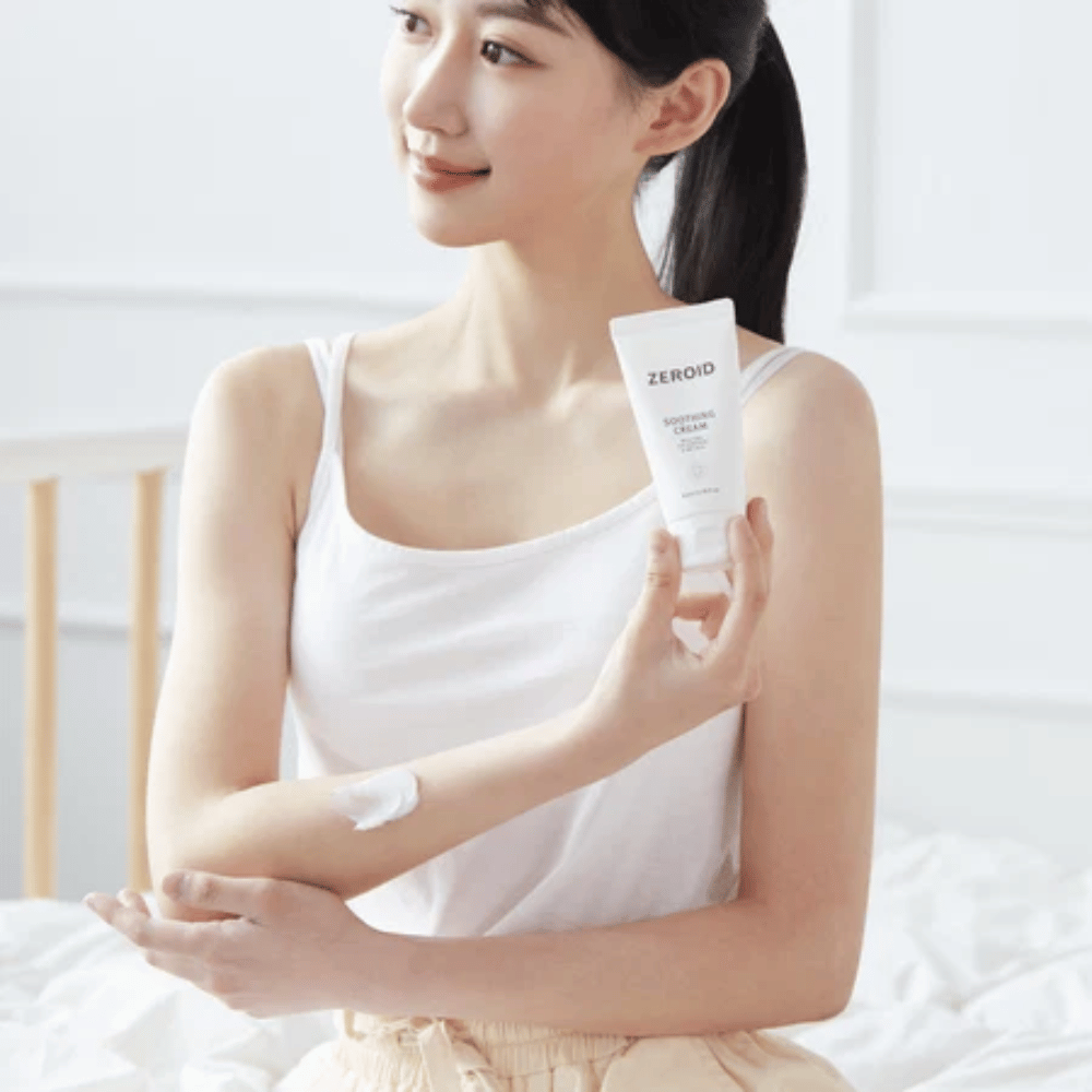Osoba nakłada ZEROID Soothing Cream na ramię, aby ukoić suchą i wrażliwą skórę