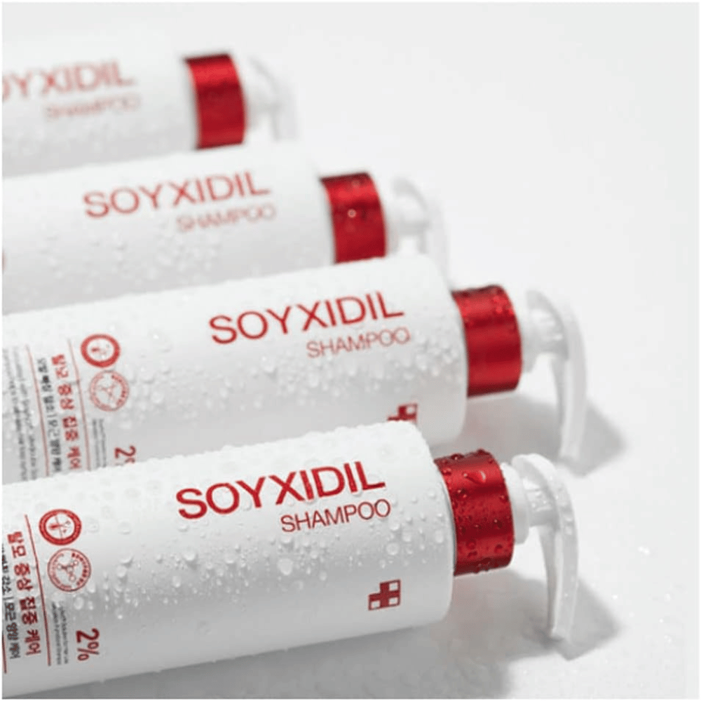 Kilka butelek Medicube Soyxidil Shampoo leży w rzędzie z kroplami wody – pokazuje świeże i pielęgnacyjne odczucie produktu.