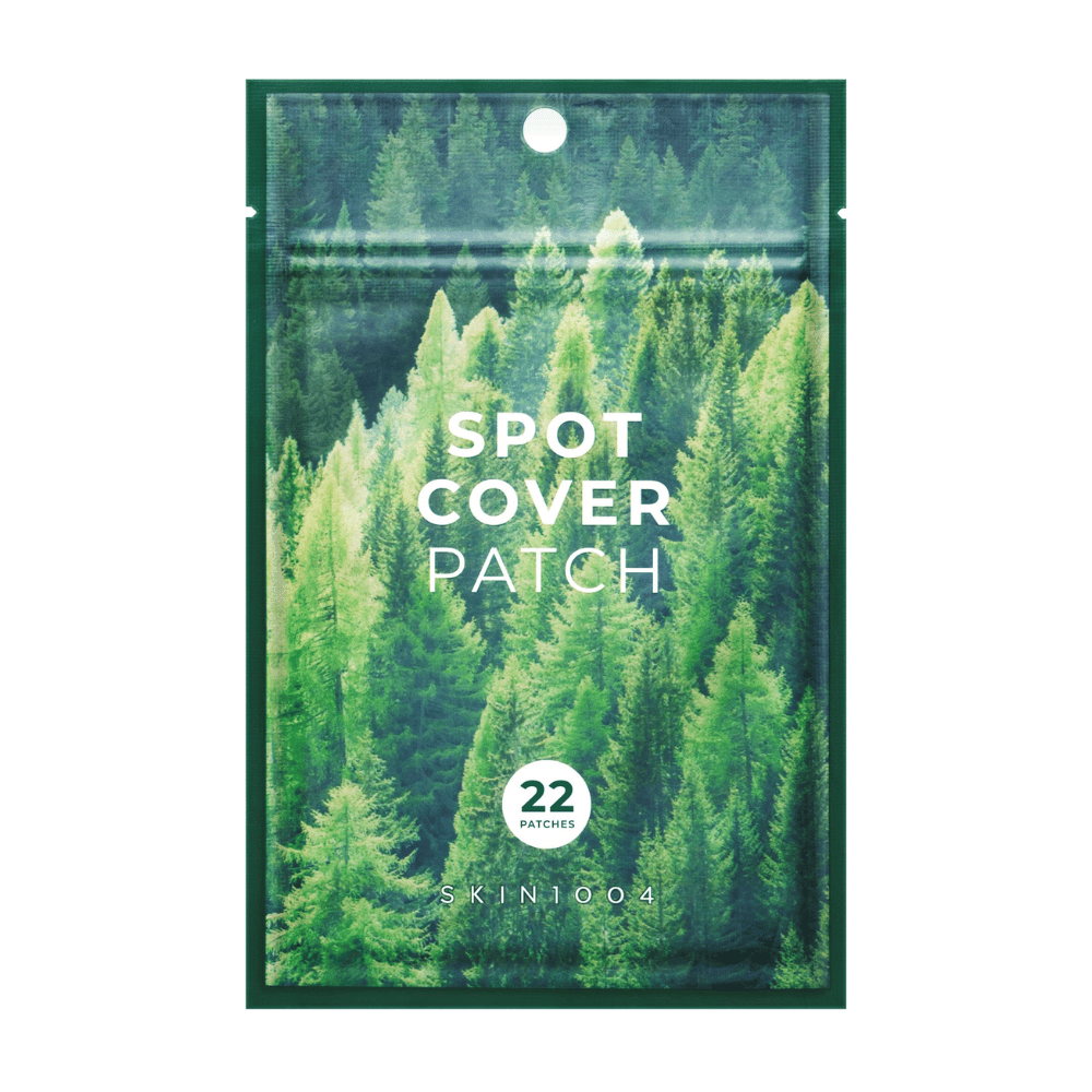 Opakowanie z "Spot Cover Patch" zawierające 22 plastry, zaprojektowane z zielonym motywem lasu. Tekst "SPOT COVER PATCH" jest wydrukowany na biało z przodu, a okrąg wskazuje liczbę plastrów. Produkt pochodzi od marki SKIN1004.