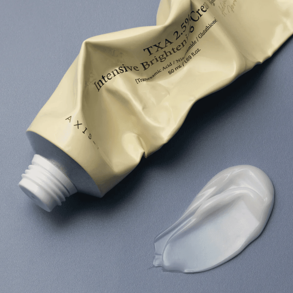 Zdjęcie produktowe z tubką i porcją kremu obok, aby pokazać miękką, kremową konsystencję i nawilżającą formułę. Nacisk położony jest na glow i równomierną aplikację.