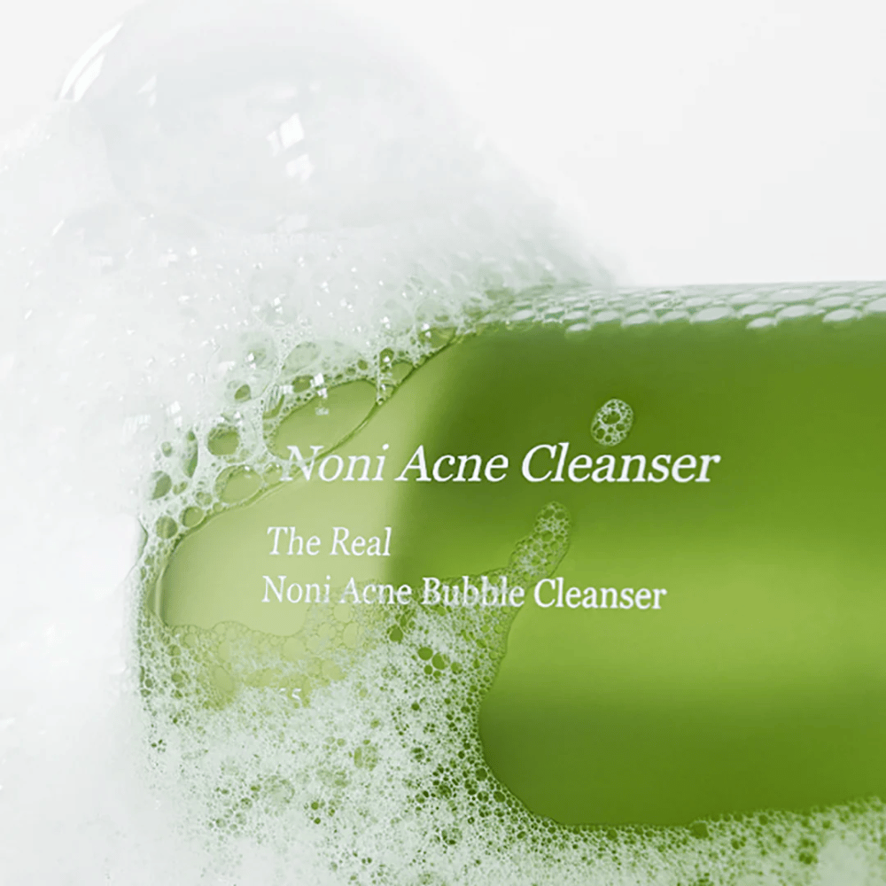 Butelka z The Real Noni Acne Bubble Cleanser jest w centrum uwagi i otoczona obfitym pianą. Świeży zielony kolor sygnalizuje naturalne składniki, idealne do czyszczenia i zwalczania trądziku. Idealny produkt dla czystej i jasnej cery.