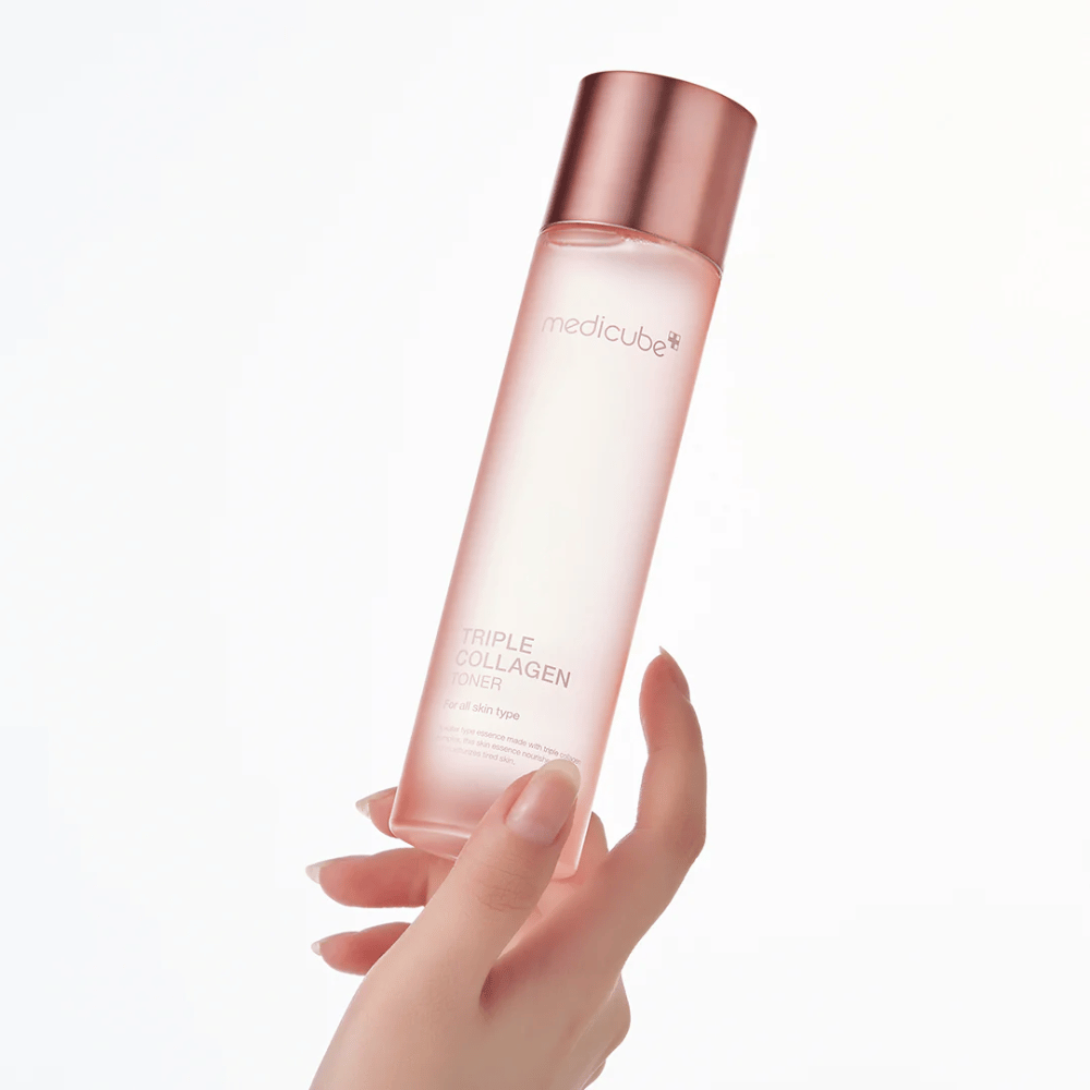 Ręka trzymająca różową butelkę Medicube Triple Collagen Toner 4.0, nawilżający i ujędrniający tonik dla każdego rodzaju skóry.