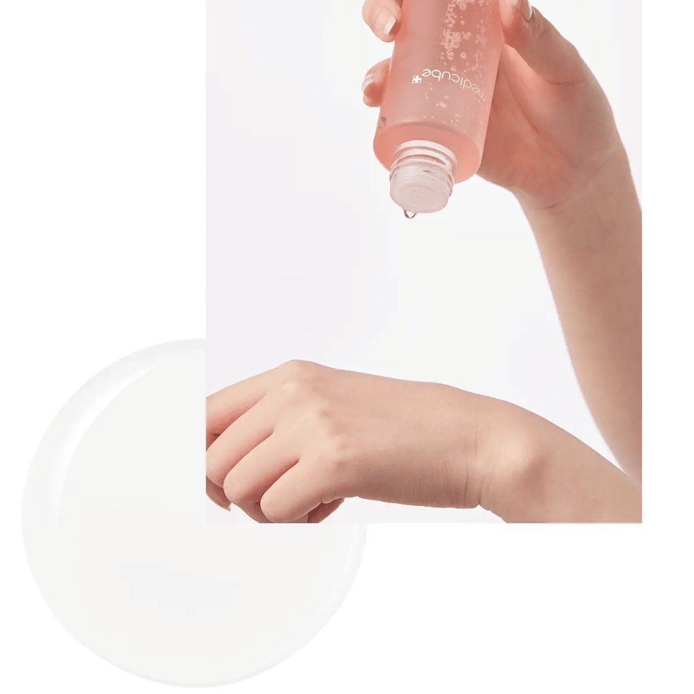 Ręka nakładająca Medicube Triple Collagen Toner 4.0 z różowej butelki na skórę, pokazuje nawilżającą konsystencję.