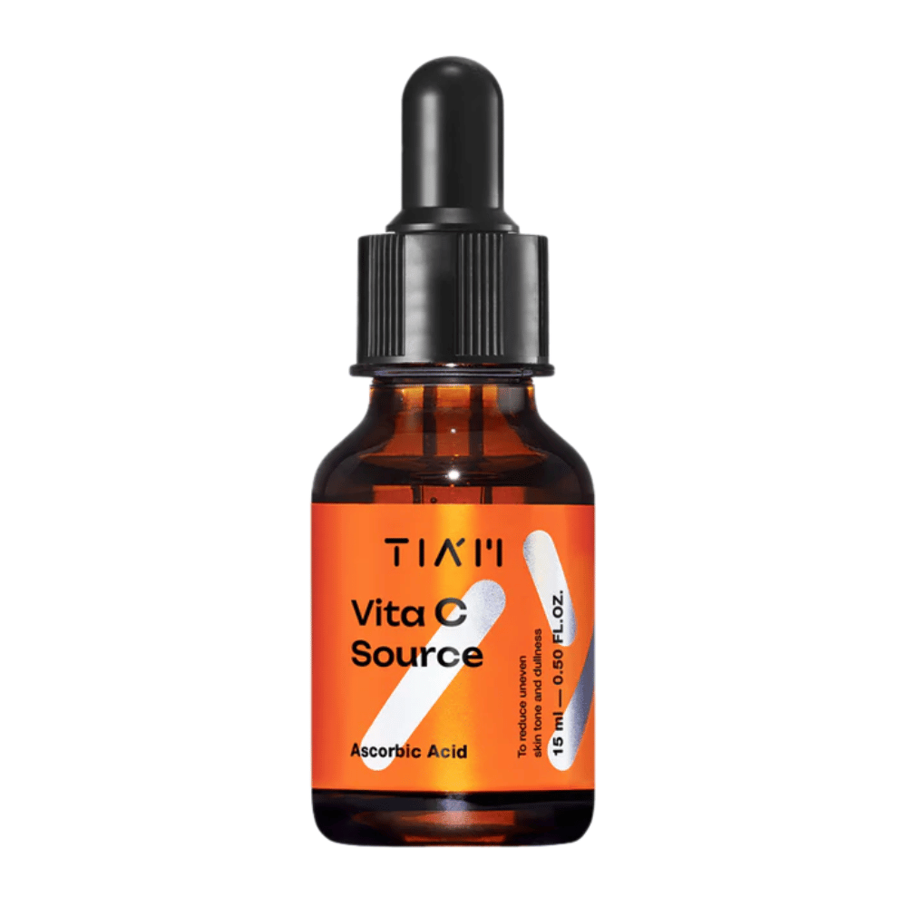 TIA'M Vita C Source, serum z kwasem askorbinowym w brązowej szklanej butelce z czarną pipetą i pomarańczową etykietą - skuteczny w rozjaśnianiu skóry i redukcji nierównego kolorytu.